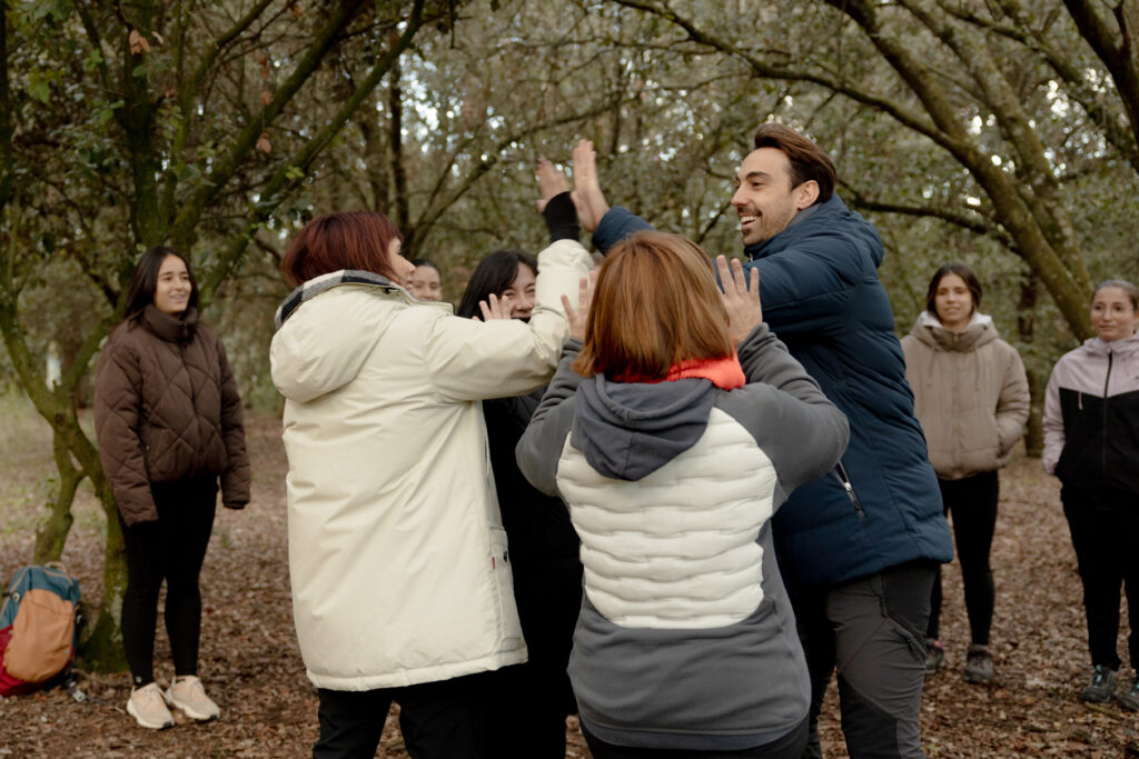 Equip celebrant una activitat de cohesió amb xoc de mans a l’aire lliure
